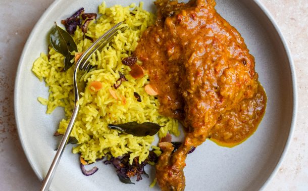 Duck rendang on a grey plate with a portion of Sri Lankan Yellow Rice.