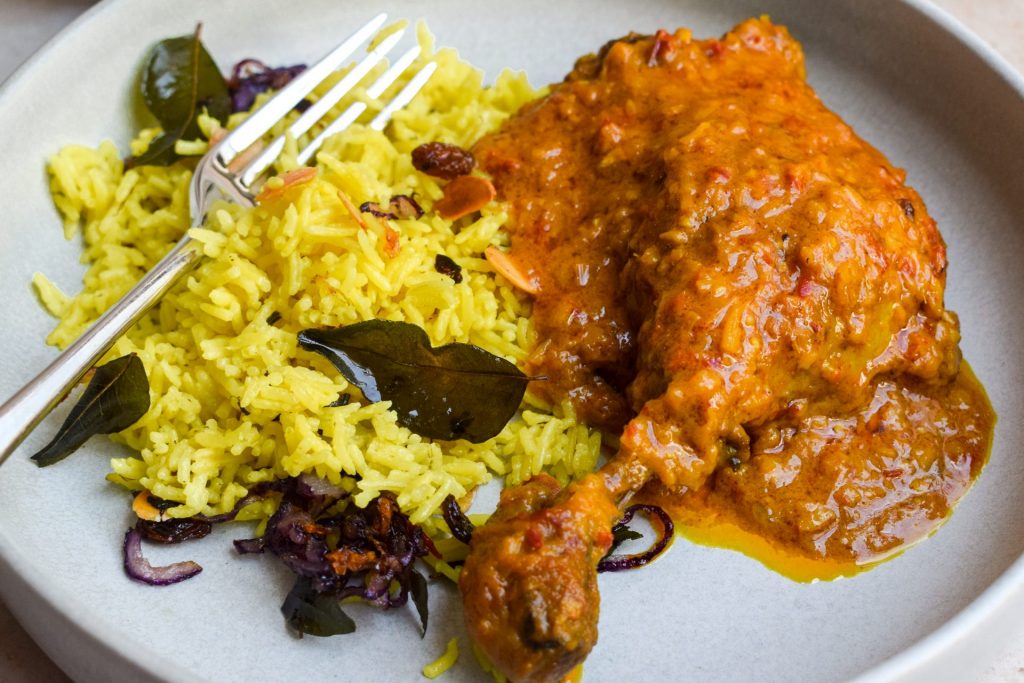 Close up of a duck leg rendang with sri lankan yellow rice.