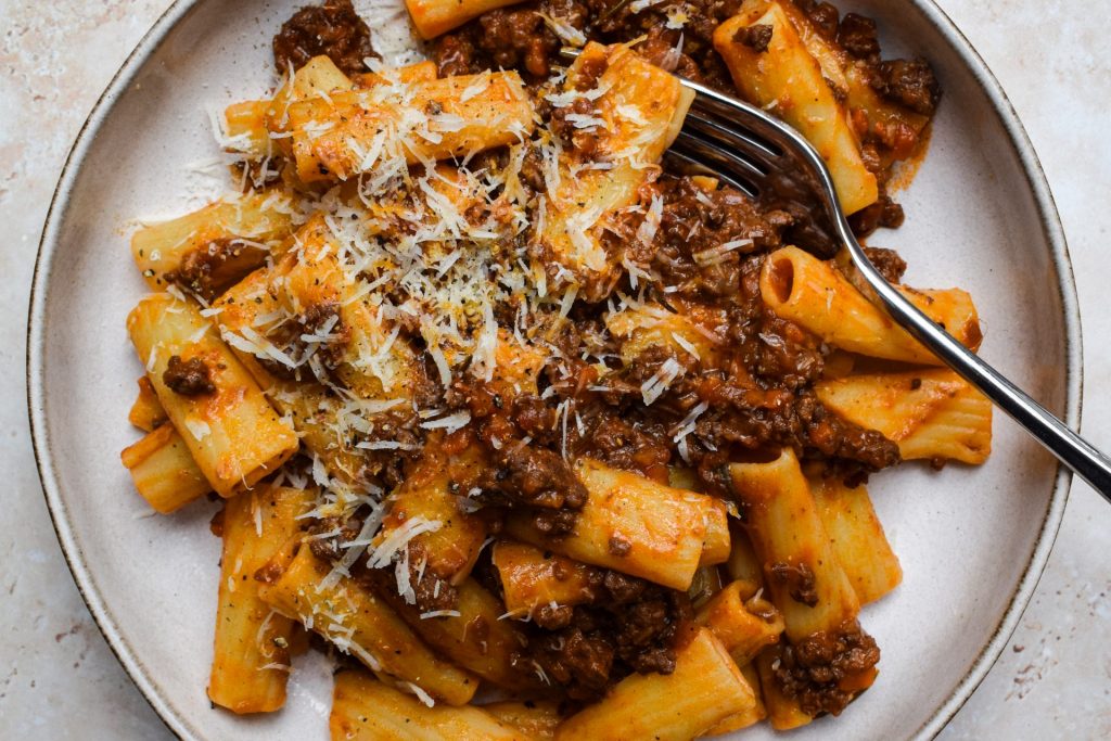 Venison Ragù tossed with rigatoni on a stone plate.