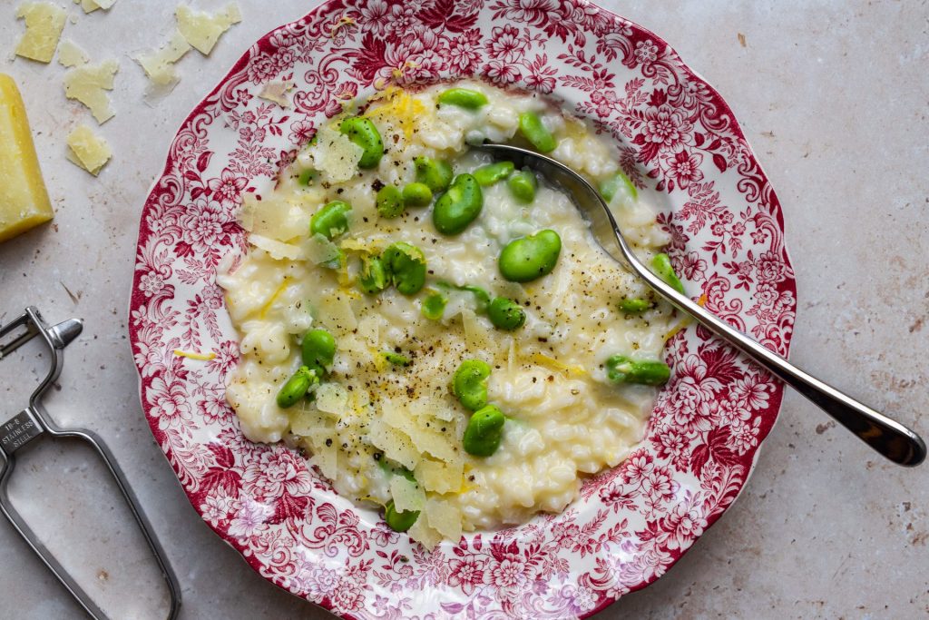 Red and white willow pattern bowl of risotto with broad beans.